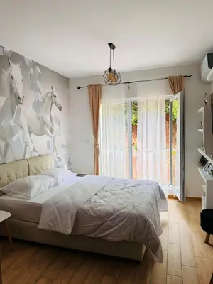 a bedroom with a bed with horses on the wall at Apartment Juliette Budva in Budva