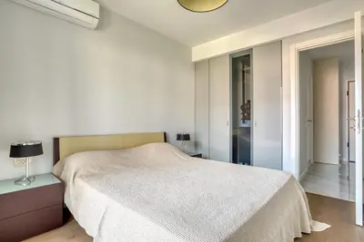 a white bedroom with a bed and a window at Apt 