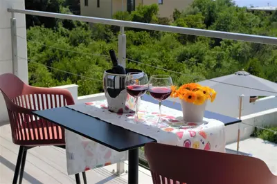 a table with two glasses of wine on a balcony at Villa Gabriela in Kotor