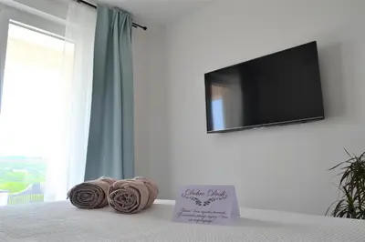 a room with a bed with a flat screen tv and towels at Villa Gabriela in Kotor