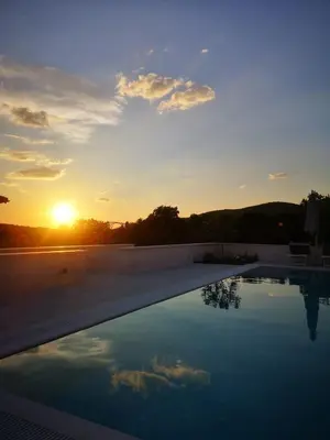 a swimming pool with the sunset in the background at Villa Gabriela in Kotor
