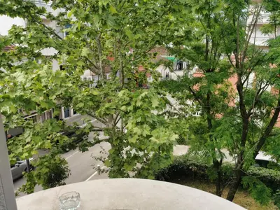 a white table with a view of a street and trees at Stars Aspava Blue HOSTEL in Podgorica