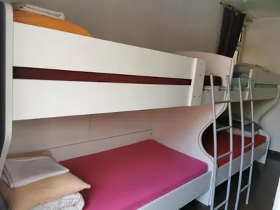 a bunk bed in a dorm room with a ladder at Stars Aspava Blue HOSTEL in Podgorica