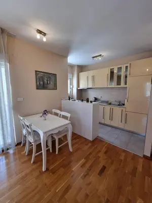 a kitchen and dining room with a white table and chairs at Sunny City - City Kvart in Podgorica