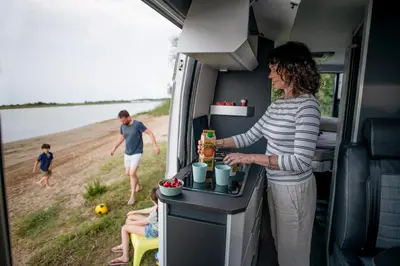 a woman preparing food in the back of an rv at Camper Montenegro and Recreational Vehicles in Budva