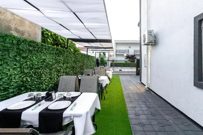 a restaurant with tables and chairs on a patio at Apart-Hotel Prestige in Ulcinj