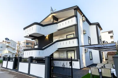 a white house with a black and white fence at Apart-Hotel Prestige in Ulcinj