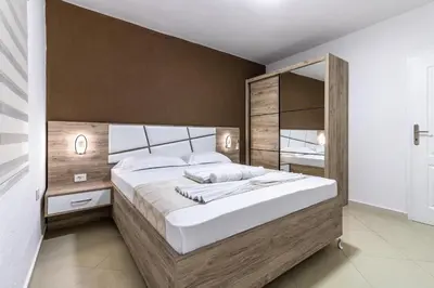 a bedroom with a large bed and a large mirror at Apart-Hotel Prestige in Ulcinj