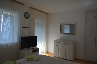 a bedroom with a flat screen tv and a bed at Apartments Djedovic 2 in Petrovac na Moru