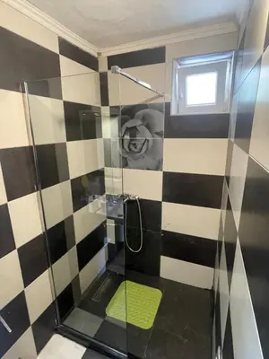 a bathroom with a shower with black and white tiles at Apartments Djedovic 2 in Petrovac na Moru