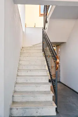 a staircase in a white building with a metal railing at Seaview Apartments Bonaca in Bar
