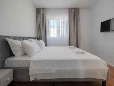 a bedroom with a large white bed with a window at Horizon Two bedroom Penthouse with Hot tub in Becici