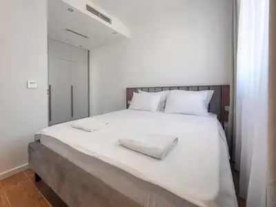 a bedroom with a large white bed with two white towels on it at Horizon Two bedroom Penthouse with Hot tub in Becici