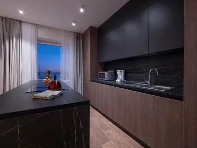 a kitchen with black cabinets and a sink and a window at Horizon Two bedroom Penthouse with Hot tub in Becici