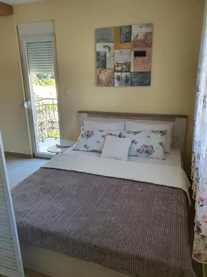 a bedroom with a bed with pillows on it at Village house DUNJA in Virpazar