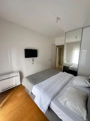 a bedroom with a large bed and a mirror at White Homes 1BR - Central Point in Podgorica