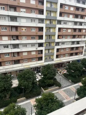 an apartment building with trees in front of it at White Homes 1BR - Central Point in Podgorica
