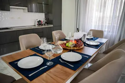 a dining room table with plates and wine glasses at Luxury Scandinavian - Villa Montenegro in Ulcinj