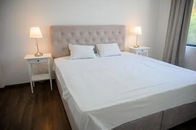 a bedroom with a large white bed with two night stands at Luxury Scandinavian - Villa Montenegro in Ulcinj