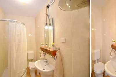 a bathroom with a sink and a toilet and a shower at Stylish apartment 22 in Kotor