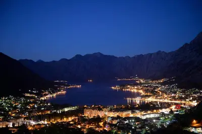 a view of a city and a lake at night at Stylish apartment 22 in Kotor