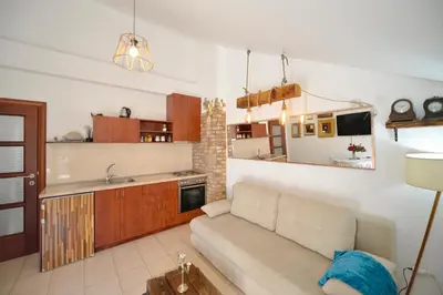 a living room with a couch and a kitchen at Stylish apartment 22 in Kotor