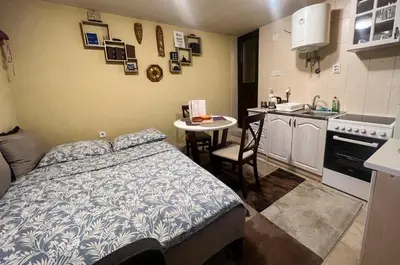 a small bedroom with a bed and a small kitchen at Green Hills II by Rent a car MI in Podgorica
