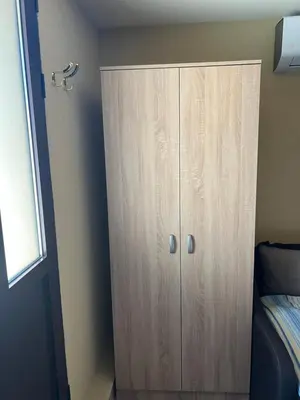 a wooden cabinet in a bedroom next to a bed at Green Hills II by Rent a car MI in Podgorica