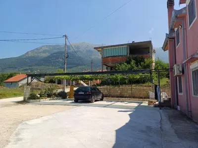 a car parked in a parking lot with a house at Apartman Balsa in Kotor