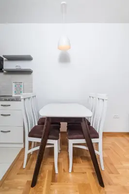 a white table and four chairs in a kitchen at Modern Spacious Fully Equipped One Bedroom Apartment in Budva, Free Parking, Ideal for Long Stays in Budva