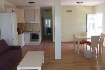 a living room and kitchen with a couch and a table at Petrovac Holiday apartments 1 in Petrovac na Moru