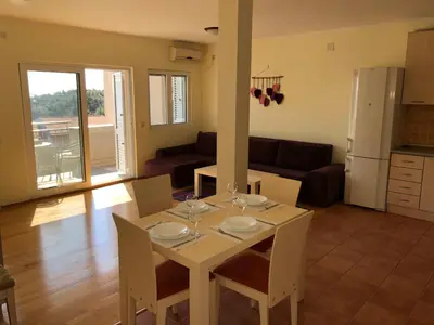 a kitchen and living room with a table and chairs at Petrovac Holiday apartments 1 in Petrovac na Moru