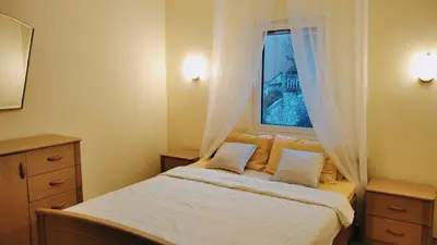 a bedroom with a bed and a window with curtains at Petrovac Holiday Apartments 2 in Petrovac na Moru