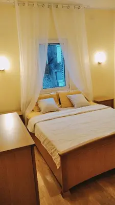 a bedroom with a large bed with a window at Petrovac Holiday Apartments 2 in Petrovac na Moru