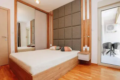 a bedroom with a large bed and a mirror at Status-M Apartments 134 in Becici