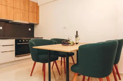a kitchen with a wooden table and green chairs at Status-M Apartments 134 in Becici