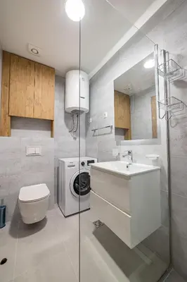 a bathroom with a toilet a sink and a washing machine at Apartments 28 Master Quart in Podgorica