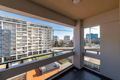 a balcony with two windows and a view of a city at Apartments 28 Master Quart in Podgorica