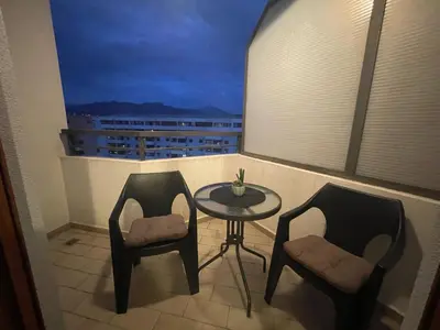 a balcony with two chairs and a table and a window at Exclusive studio, great location in Podgorica
