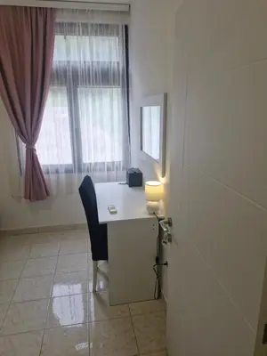 a white desk with a chair and a window at Apartments Plaza in Ulcinj