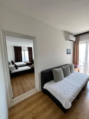 a living room with a couch and a mirror at Apartments Plaza in Ulcinj