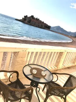 a table and two chairs on a balcony overlooking the ocean at Lovely Apartment Sveti Stefan in Sveti Stefan