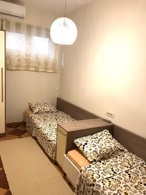 a room with two beds and a chandelier at Lovely Apartment Sveti Stefan in Sveti Stefan