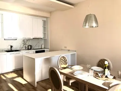 a kitchen with white cabinets and a table with chairs at Lovely Apartment Sveti Stefan in Sveti Stefan