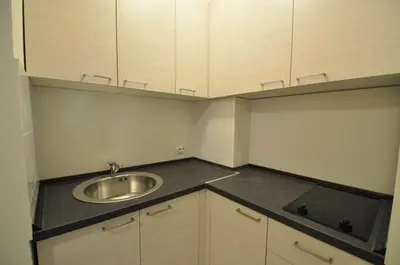 a small kitchen with a sink and white cabinets at Rafailovici Holiday Apartments in Rafailovici