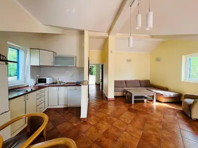 a kitchen and living room with a couch and a table at Rafailovici Holiday Apartments in Rafailovici