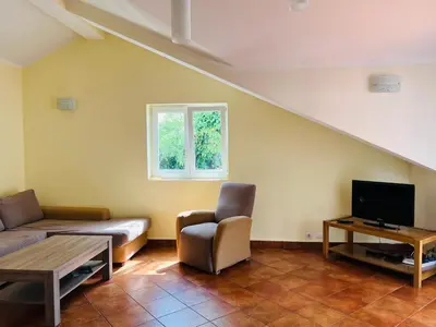 a living room with a couch and a tv at Rafailovici Holiday Apartments in Rafailovici