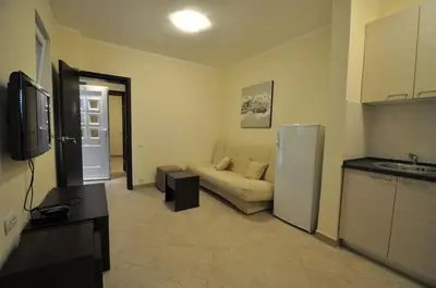 a living room with a couch and a refrigerator at Rafailovici Holiday Apartments in Rafailovici