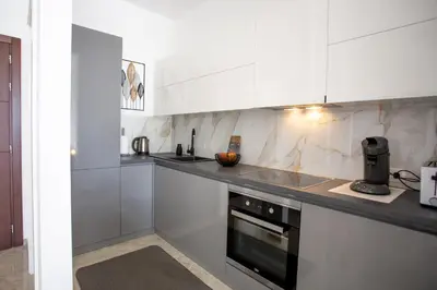 a kitchen with white cabinets and a sink and a stove at The Dream Getaway & Spa by DeVasco in Becici