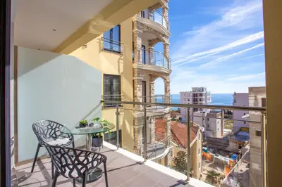 a balcony with a table and a view of the city at The Dream Getaway & Spa by DeVasco in Becici